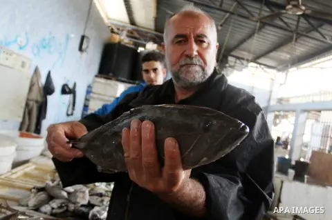 A Palestinian fisherman sells fish in a market in Rafah in the southern Gaza Strip, on May 7, 2015. Israeli military boats on Wednesday afternoon opened fire at Palestinian fishing boats near the shore of the central Gaz...