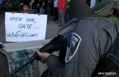 Palestinian protesters from the East Jerusalem village of al-Zaim, wave Palestinian flags as they confront Israeli Border Police during a protest demanding the opening of the only gate in the separated barrier leading fr...