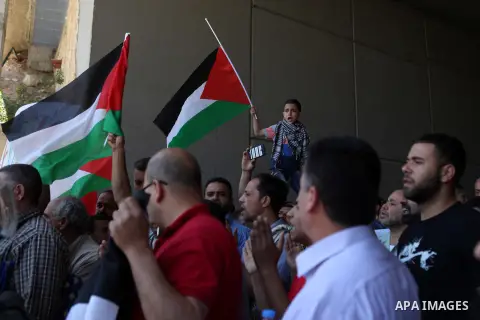 Palestinian protesters from the East Jerusalem village of al-Zaim, wave Palestinian flags as they confront Israeli Border Police during a protest demanding the opening of the only gate in the separated barrier leading fr...