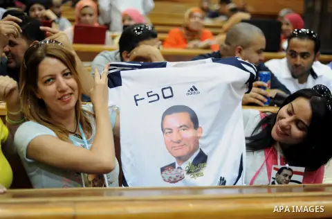 Supporters of ousted Egyptian president Hosni Mubarak hold up a tee-shirt bearing his portrait during his verdict hearing in a retrial for embezzlement on May 9, 2015 in the capital Cairo. The Egyptian court sentenced Mu...