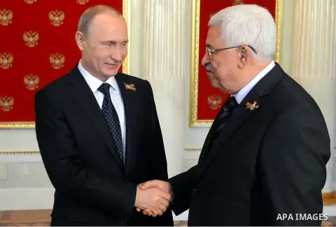 Russian President Vladimir Putin, left, welcomes Palestinian President Mahmoud Abbas during a ceremony in the Kremlin prior to the Victory Parade marking the 70th anniversary of the defeat of the Nazis in World War II, i...