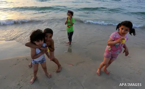 Palestinian children enjoy their time during sunset at the beach of Gaza sea on May 9, 2015. Photo by Mohammed Asad