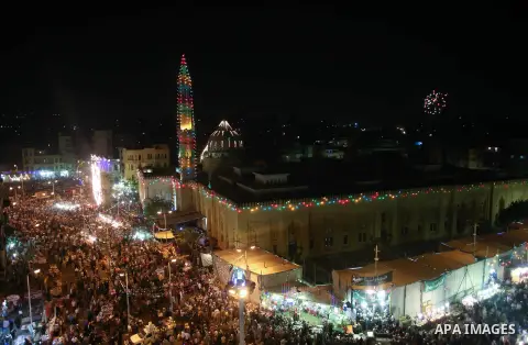 People walk in front of Sayida Zeinab mosque as they celebrate the birthday of Sayida Zeinab, the granddaughter of Prophet Mohammad, near her shrine in Cairo, May 12, 2015. Photo by Amr Sayed