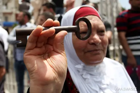 A Palestinian woman carries a key during a march ahead of the commemorations of the 67th anniversary of the ''Nakba'', in the West Bank city of Ramallah on May 13, 2015. ''Nakba'' means in Arabic ''catastrophe'' in refer...