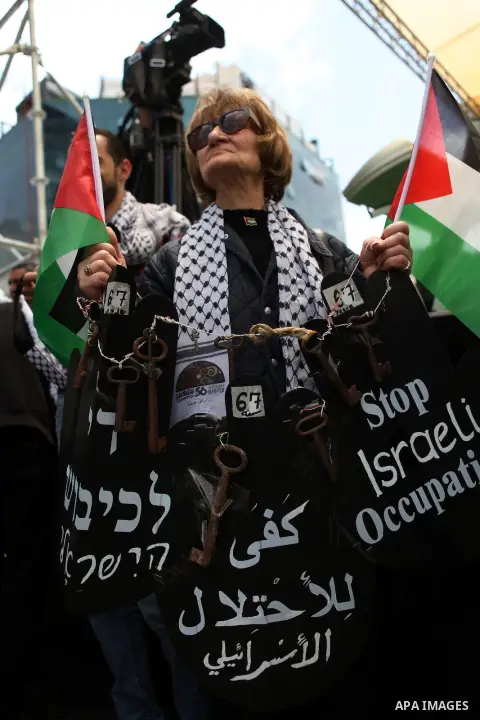 A Palestinian woman carries keys during a march ahead of the commemorations of the 67th anniversary of the ''Nakba'', in the West Bank city of Ramallah on May 13, 2015. ''Nakba'' means in Arabic ''catastrophe'' in refere...