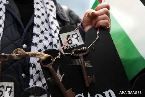 A Palestinian woman carries keys during a march ahead of the commemorations of the 67th anniversary of the ''Nakba'', in the West Bank city of Ramallah on May 13, 2015. ''Nakba'' means in Arabic ''catastrophe'' in refere...