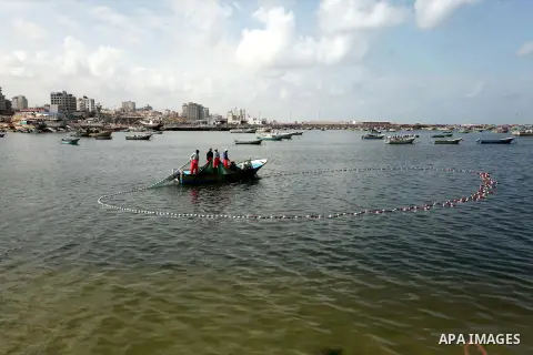Palestinian fishermen throw their net into the sea at the beach of Gaza City during a rally to show solidarity with Third Freedom Flotilla and to demand break the Israeli blockade on the Gaza strip in Gaza port on May 14...