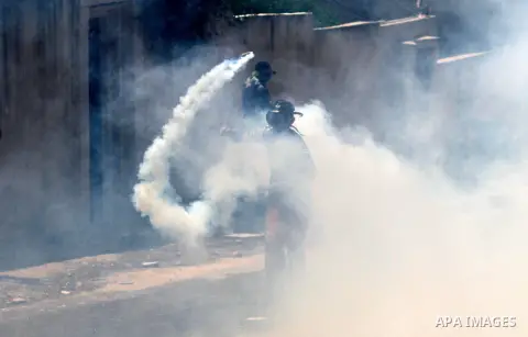 A Palestinian protester hurls back a tear gas canister fired by Israeli forces during clashes following a demonstration to mark the 67th anniversary of the "Nakba" in the village of Kfar Qaddum, near Nablus, in the occup...