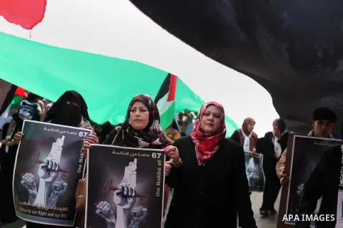 Palestinians women walk under a large Palestinian flag during a march to mark the 67th anniversary of the "Nakba", in Gaza City on May 16, 2015. "Nakba" means in Arabic "catastrophe" in reference to the birth of the stat...
