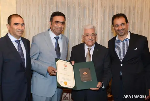 Palestinian President Mahmoud Abbas honors the family of Palestinian martyr Mohammed al-Rosan, in Amman on May 18, 2015. Photo by Thaer Ganaim