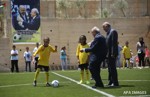FIFA chief Sepp Blatter plays soccer with Palestinian children during his visit to Dura al-Qar' village in the West Bank city of Ramallah May 20, 2015. Blatter, visiting the Middle East to try to persuade the Palestine F...