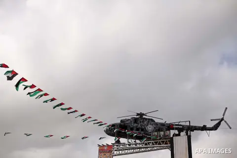 The broken helicopter of late Palestinian President Yasser Arafat is placed on top of a structure as members of Palestinian security forces march during a military graduation ceremony in Gaza City May 21, 2015. Photo by...