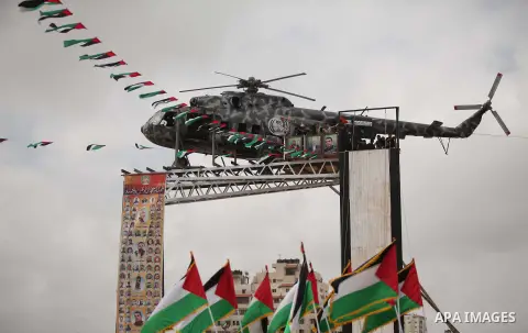 The broken helicopter of late Palestinian President Yasser Arafat is placed on top of a structure as members of Palestinian security forces march during a military graduation ceremony in Gaza City May 21, 2015. Photo by...