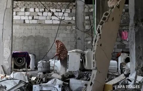 A Palestinian woman cleans her house, which was damaged during the recent Israeli war, in Rafah in the southern Gaza strip, on May 23, 2015. Photo by Abed Rahim Khatib