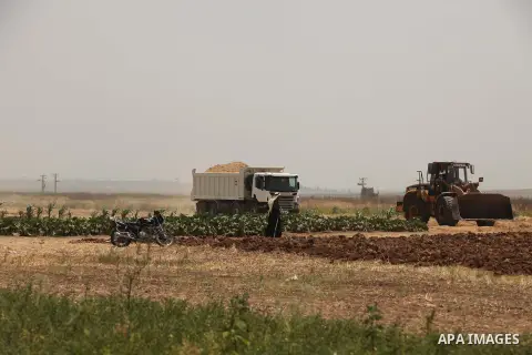 Palestinian workers use a bulldozer to build a street near the border with Israel, in Gaza City, on May 23, 2015. Photo by Ashraf Amra