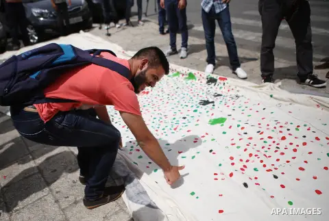 Palestinians lay hands imprint as they take part in a rally marking the 67th anniversary of the "Nakba, in the West Bank city of Ramallah, on May 26, 2015. Photo by Shadi Hatem