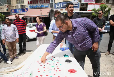 Palestinians lay hands imprint as they take part in a rally marking the 67th anniversary of the "Nakba, in the West Bank city of Ramallah, on May 26, 2015. Photo by Shadi Hatem