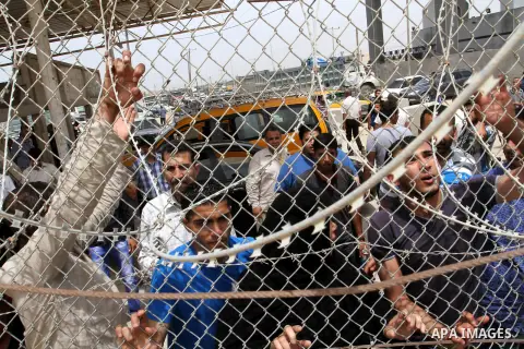 Palestinians stand behind fences as they wait their relatives coming from Egypt to the Gaza Strip through the Rafah border crossing between Egypt and southern Gaza Strip May 26, 2015. Egyptian authorities opened the Rafa...