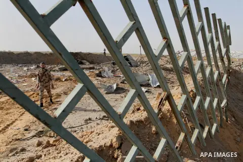 A Palestinian security man looks at a crater on the ground following an Israeli airstrike in the southern Gaza Strip near the town, of Rafah on May 27,2015. The Israeli air force carried out four strikes on militant targ...
