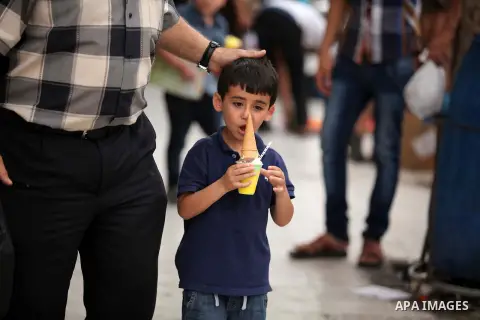 Palestinians buy ice-cream during hot weather in Gaza city on May 27, 2015. Hot weather hit Gaza Strip on Wednesday, and the temperature reached more than 39 degrees Celsius (102 degree Fahrenheit) at noon, Gazans escape...
