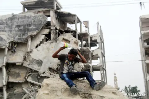 A Palestinian boy washes himself as he sits on the rubble of his family's house, which was destroyed during the 50-day Israeli war in the summer of 2014, in Beit Lahia in the northern Gaza Stip, May 28, 2015. Photo by Ni...