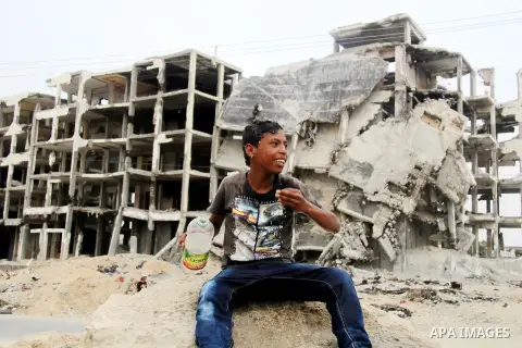 A Palestinian boy washes himself as he sits on the rubble of his family's house, which was destroyed during the 50-day Israeli war in the summer of 2014, in Beit Lahia in the northern Gaza Stip, May 28, 2015. Photo by Ni...