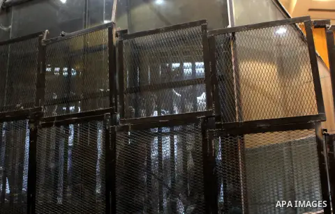 Egyptian defendants sit behind bars during their trial over a 2012 stadium riot in the canal city of Port Said that left 74 people dead on May 30, 2015 at the police academy in Cairo. The Egyptian court postponed its ver...