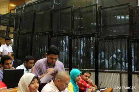 Egyptian defendants sit behind bars during their trial over a 2012 stadium riot in the canal city of Port Said that left 74 people dead on May 30, 2015 at the police academy in Cairo. The Egyptian court postponed its ver...