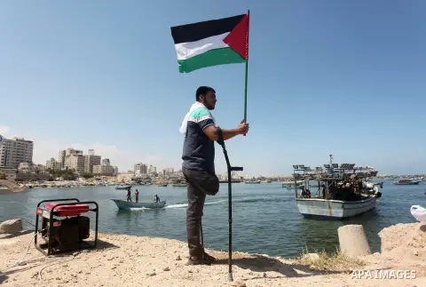 Palestinians hold flags during a rally marking the 5th anniversary of the Mavi Marmara Gaza flotilla incident, at the seaport of Gaza City May 31, 2015. Nine activists, eight Turkish and one Turkish-American, died on May...
