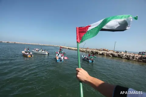 Palestinians hold flags as they ride a boat during a rally marking the 5th anniversary of the Mavi Marmara Gaza flotilla incident, at the seaport of Gaza City May 31, 2015. Nine activists, eight Turkish and one Turkish-A...
