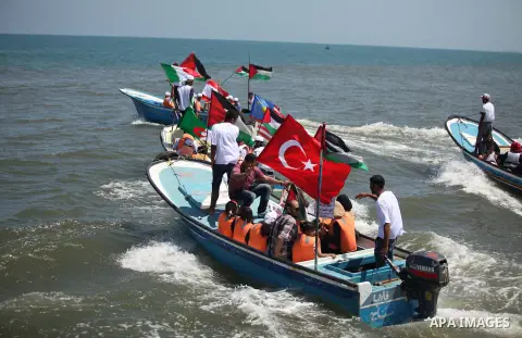 Palestinians hold flags as they ride a boat during a rally marking the 5th anniversary of the Mavi Marmara Gaza flotilla incident, at the seaport of Gaza City May 31, 2015. Nine activists, eight Turkish and one Turkish-A...