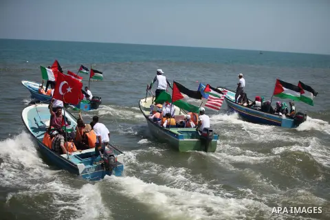 Palestinians hold flags as they ride a boat during a rally marking the 5th anniversary of the Mavi Marmara Gaza flotilla incident, at the seaport of Gaza City May 31, 2015. Nine activists, eight Turkish and one Turkish-A...
