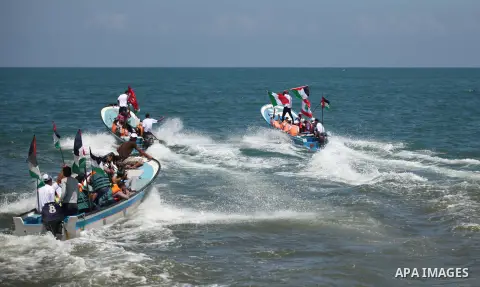 Palestinians hold flags as they ride a boat during a rally marking the 5th anniversary of the Mavi Marmara Gaza flotilla incident, at the seaport of Gaza City May 31, 2015. Nine activists, eight Turkish and one Turkish-A...