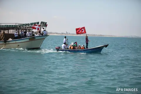 Palestinians hold flags as they ride a boat during a rally marking the 5th anniversary of the Mavi Marmara Gaza flotilla incident, at the seaport of Gaza City May 31, 2015. Nine activists, eight Turkish and one Turkish-A...