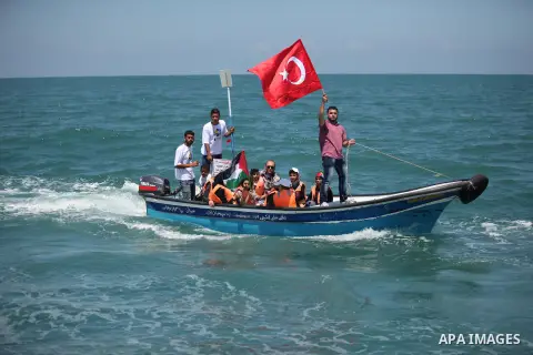Palestinians hold flags as they ride a boat during a rally marking the 5th anniversary of the Mavi Marmara Gaza flotilla incident, at the seaport of Gaza City May 31, 2015. Nine activists, eight Turkish and one Turkish-A...