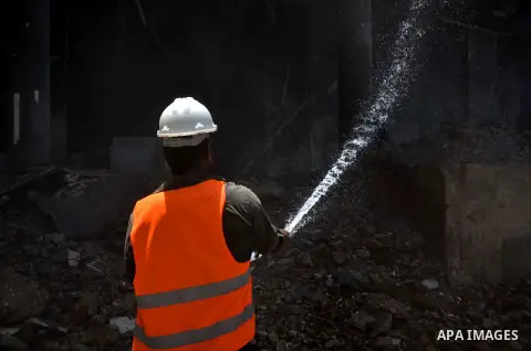 An Egyptian worker sprays water during the demolition of the headquarters of the once-dominant party of ex-president Hosni Mubarak that was torched during the 2011 uprising that toppled him, on May 31, 2015 in the capita...