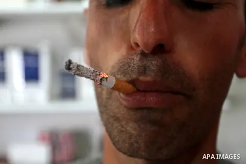 A Palestinian man smokes cigarettes in the southern Gaza Strip City of Rafah, on May 23, 2015. Smuggling through tunnels began several months after Islamic Hamas movement's control of the Gaza Strip and the Israeli block...