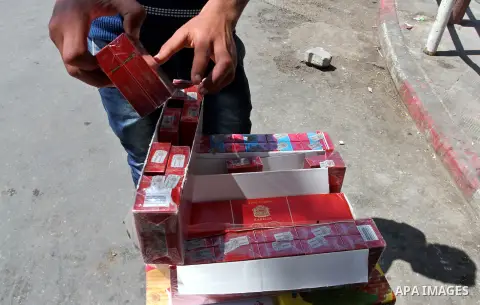 A Palestinian street vendor sells cigarettes in the southern Gaza Strip City of Rafah, on May 31, 2015. Smuggling through tunnels began several months after Islamic Hamas movement's control of the Gaza Strip and the Isra...