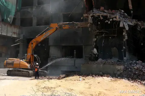 An Egyptian worker sprays water during the demolition of the headquarters of the once-dominant party of ex-president Hosni Mubarak that was torched during the 2011 uprising that toppled him, on May 31, 2015 in the capita...
