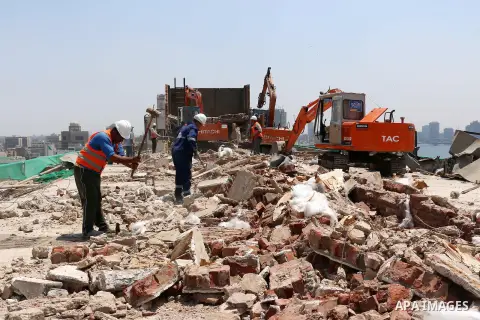 Egyptian workers use a bulldozer during the demolition of the headquarters of the once-dominant party of ex-president Hosni Mubarak that was torched during the 2011 uprising that toppled him, on May 31, 2015 in the capit...