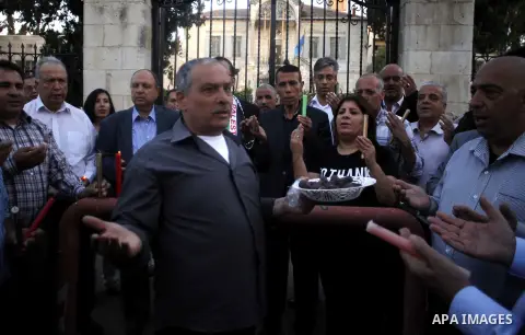 Palestinians take part in a memorial ceremony marking the 14th anniversary of the death of Faisal al-Husseini, Palestinian Authority's representative for Jerusalem affairs, outside the Orient House, which used to be the...