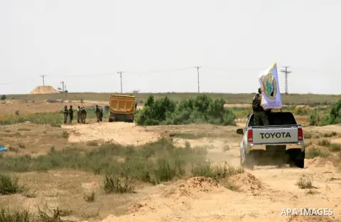 Palestinian militants of the Ezzedine al-Qassam Brigades, Hamas' armed wing, patrol an area 300 meters from the Israeli border with Rafah in the southern Gaza Strip, on June 03, 2015. Israeli troops backed by military ve...