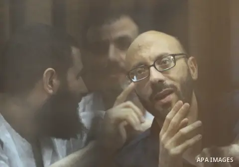 Egyptian Muslim Brotherhood Members sit at defendants cage as they attend their trial along with former president Mohamed Morsi at Cairo criminal court on June 7, 2015. Cairo criminal court considers today, Sunday a new...