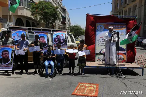 Palestinians attend Friday prayers outside the Red Cross headquarter in support of the Palestinian, Khader Adnan, a senior member of the Islamic Jihad who was jailed in Israel without a trial, in Gaza city on June 12, 20...