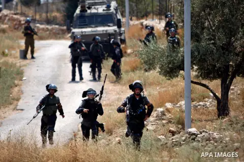 Israeli security forces run after Palestinian protesters during clashes following a demonstration against Jewish settlements in the West Bank village of Bilin, west of Ramallah, June 12, 2015. Photo by Shadi Hatem