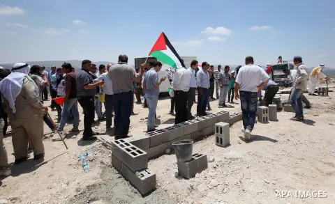 Palestinian protesters hold flags and banners during a protest against settlement expansion of Jewish settlements on Palestinian land, in the West Bank village of Jammai'n near Nablus, on June 13, 2015. Photo by Stranger