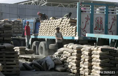Palestinian workers offload a truck loaded with cement after it entered from Egypt through the Rafah border crossing in southern Gaza Strip, on June 13, 2015. Egyptian authorities for the first time since the expulsion o...