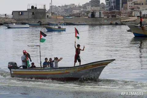 Palestinian children hold flags and banners during a rally to show solidarity with Third Freedom Flotilla in Gaza port on June 14, 2015. The flotilla is the third of its kind since 2010, when the first Freedom Flotilla w...
