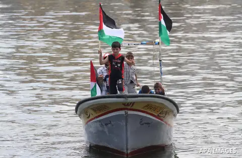 Palestinian children hold flags and banners during a rally to show solidarity with Third Freedom Flotilla in Gaza port on June 14, 2015. The flotilla is the third of its kind since 2010, when the first Freedom Flotilla w...