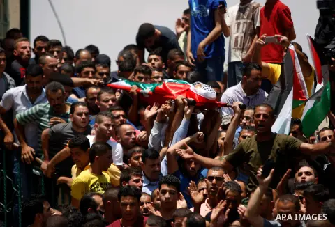 Mourners carry the body of 21-year-old Palestinian Abdallah Ghanayem, during his funeral in the village of Kafr Malik, northeast of Ramallah on June 14, 2015. An army spokesman said that the Palestinian had died after he...